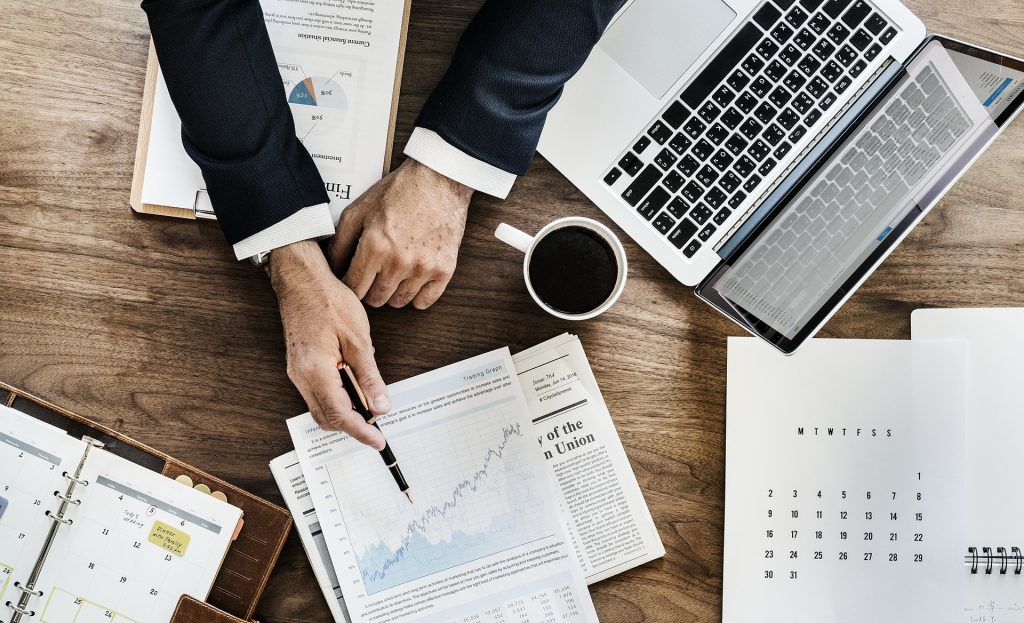 person analyzing data chart spread on a desk